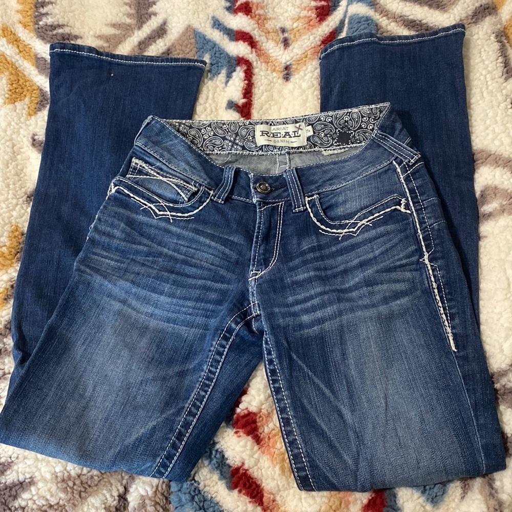 Brand: Ariat. Style: R.E.A.L. Mid Rise Stretch Entwined Boot Cut. Size: 27R.